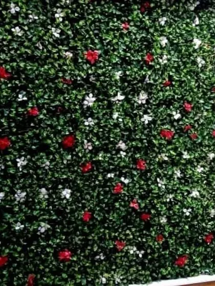 A full view of the artificial wall with scattered red and white flowers. This is a great option for a balcony or terrace wall that needs a pop of color.