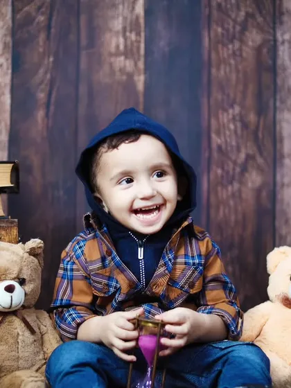 A joyful, laughing toddler enjoying his second birthday session in the studio.