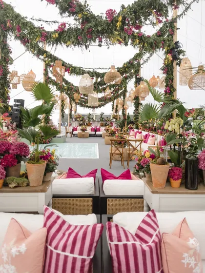 A wide view of the Mehendi setup, showing the spacious lounge seating, dance floor, and abundant floral decor. We design our spaces to be both beautiful and functional for a large number of guests.