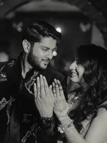 A classic black and white portrait showing the bride's intricate henna and the couple's happy smiles after their engagement.
