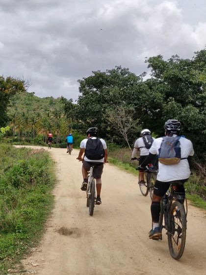 A group of cyclists on a dirt road during our 'Nandi Countryside' ride. The route is a mix of gentle trails and quiet roads, perfect for an evening adventure.