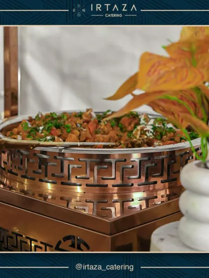 A close-up of one of our hearty main dishes, steaming in a beautiful copper and gold serving dish, ready to be enjoyed by your guests.