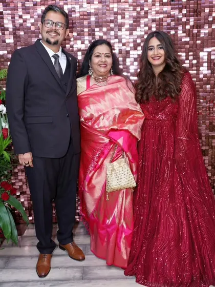 This bride chose a classic red gown for her reception. The makeup is glamorous with a defined eye and a matching red lip, while her hair is styled in soft, flowing waves.