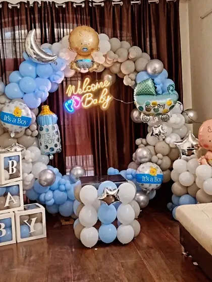 A cozy and cute "Welcome Baby" decoration for a boy. This setup includes a circular balloon arch, "BABY" blocks, and multiple baby-themed foil balloons, perfect for a living room celebration.