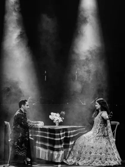 Every love story begins with a simple conversation. We recreated the couple's first coffee date on stage, using dramatic spotlights to create an intimate, theatrical setting for the start of their performance.