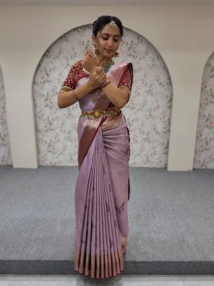 A full-length shot of a model in a lavender silk saree. The pleats are kept crisp and uniform, and the pallu is draped neatly to create a sophisticated and modern ethnic look.