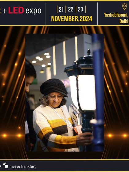 A visitor closely inspects an outdoor lighting fixture, showcasing the hands-on opportunity to evaluate product quality and design.