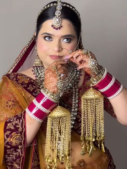 A close-up of the bride adjusting her nath, showing off her striking blue eyes and the detailed makeup.