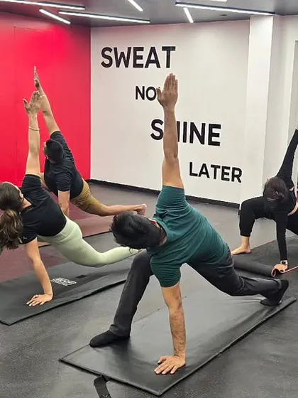 My foundation is in traditional yoga, which informs all my corporate programs. Here in a studio class, we are practicing a spinal twist that improves flexibility and releases tension, a key benefit for office workers.