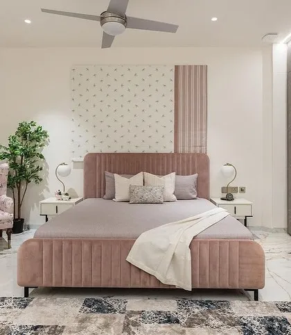 A wider view of the pink bedroom, showing the bed, a floral accent chair, and a sleek dresser, all custom-made by us for this special project.