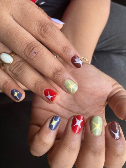 For the client who couldn't pick just one color. This short nail design features a retro starburst pattern on a mix of earthy tones like red, green, blue, and brown. It's quirky, colorful, and so much fun.