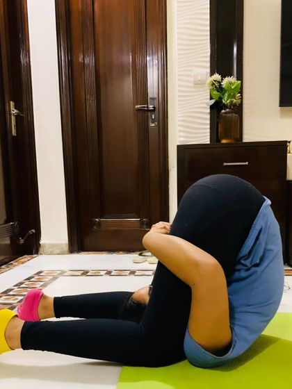 A student in Karnapidasana (Knee-to-Ear Pose), a deep inversion that she has worked diligently to achieve.