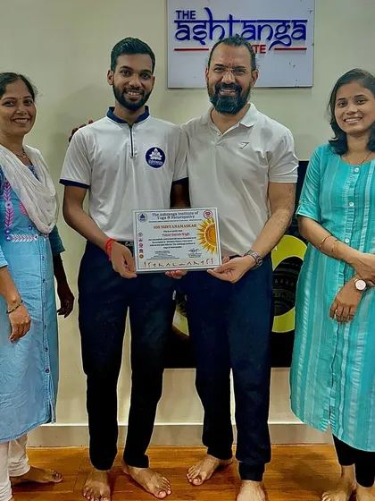 A student proudly receives his certificate from me. We celebrate every milestone on our students' path to becoming confident yoga professionals.