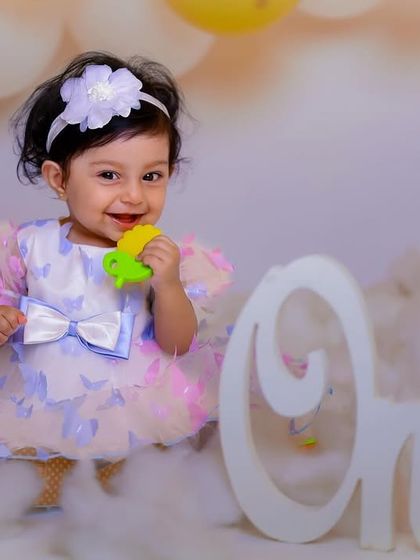 A sweet and simple first birthday portrait. Her charming smile is the centerpiece of this lovely shot.