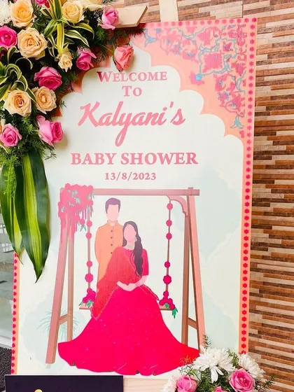 We create custom welcome signs to greet your guests. This illustrated welcome board for Kalyani's baby shower features a beautiful drawing of the couple, complemented by fresh flower arrangements that match the event's decor.