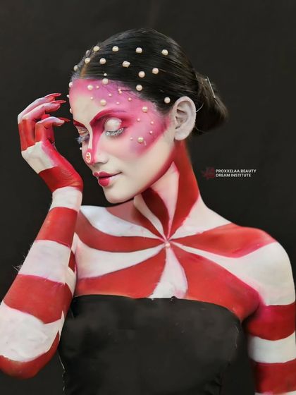 A final pose showing the full effect of the swirling red and white pattern. This is makeup as a form of storytelling.