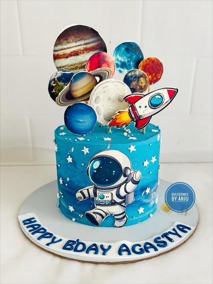 A vibrant space explorer cake with an astronaut and a full solar system of planet toppers.