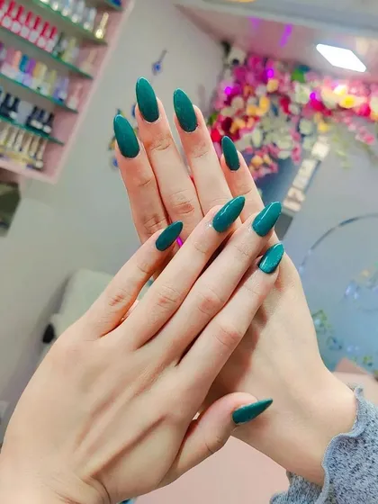 A chic and simple set of long, almond-shaped nails in a beautiful solid teal green color. This look is elegant and makes a statement with its rich hue.