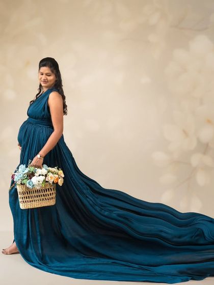 Capturing life's precious moments with love and care. This dreamy portrait features a flowing teal gown and a basket of flowers.