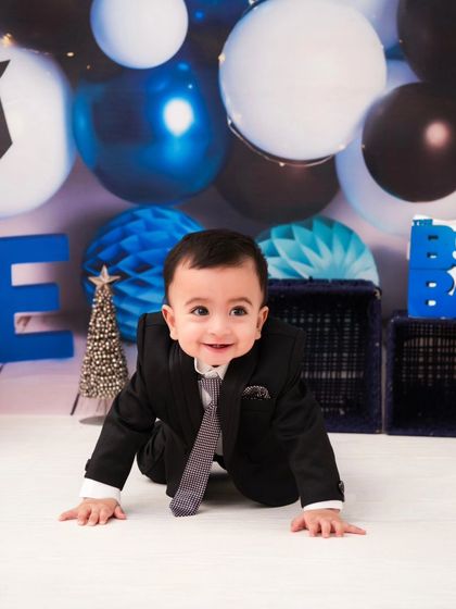 Our little 'Boss Baby' on the move. This crawling shot adds a playful and dynamic element to the themed birthday session.