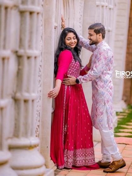 An intimate moment against a wall of white pillars, a simple yet elegant backdrop for a romantic photo.