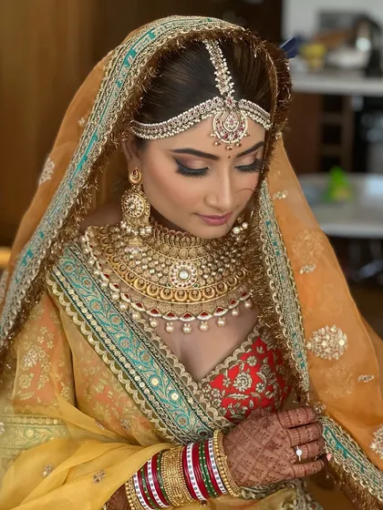A close-up showcasing the intricate details of the bridal makeup. The winged eyeliner, shimmery eyeshadow, and perfectly placed bindi complete this royal look.
