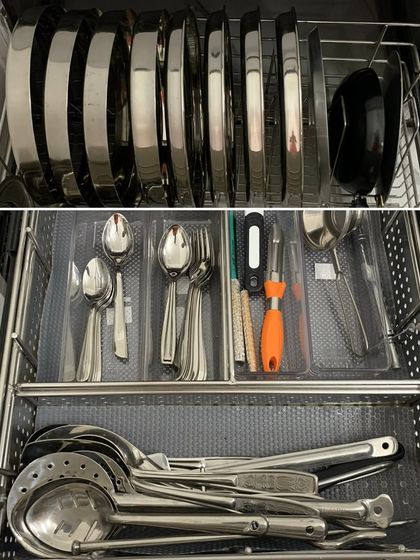 A multi-level drawer system. The top holds lids and cutlery, while the bottom is for larger ladles and serving spoons, making smart use of a deep drawer.