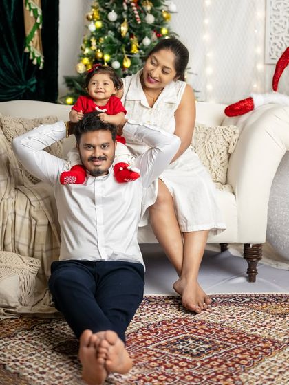 A fun and playful pose with the baby sitting on her father's shoulders. These are the happy, carefree moments that define family.
