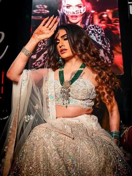 A powerful shot of Sushant Divgikar in a heavily embellished lehenga. The makeup is full glam, with a smokey eye, contoured cheeks, and a bold lip, designed to stand out on stage.