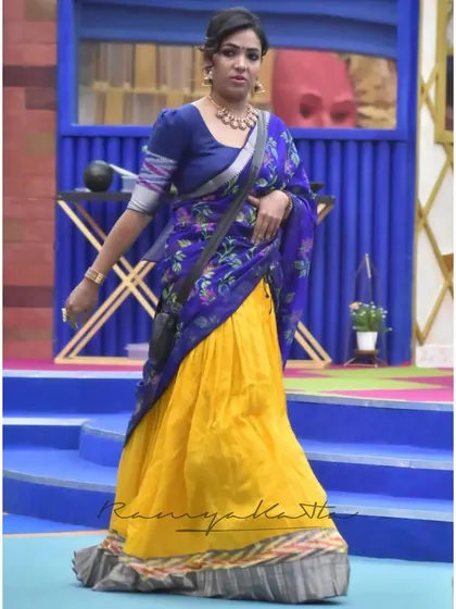 Actress Anupama Gowda in a vibrant half saree look, featuring a deep mustard pleated handloom Mangalagiri silk lehenga and a serene indigo blue floral dupatta.