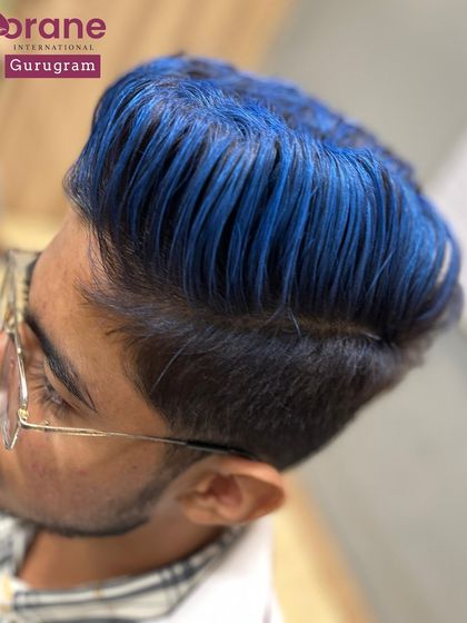 This side profile shows the sharp fade that accompanies the blue hair color. A great haircut is the canvas for any creative color, and I teach both skills in tandem.