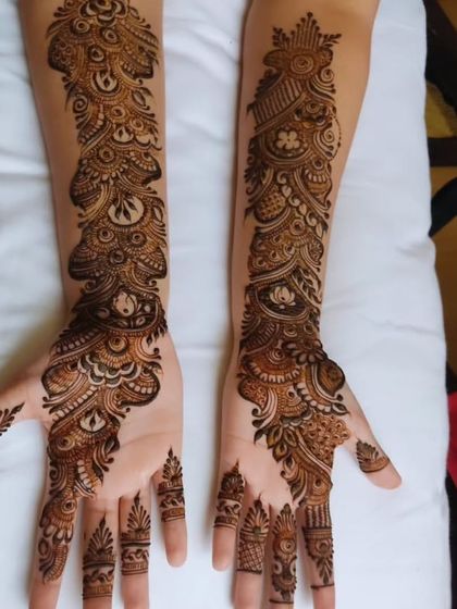 A classic Indo-Arabic style where a flowing pattern covers the hands from the wrist to the fingertips. The design is dense with peacock-inspired motifs and fine lines.