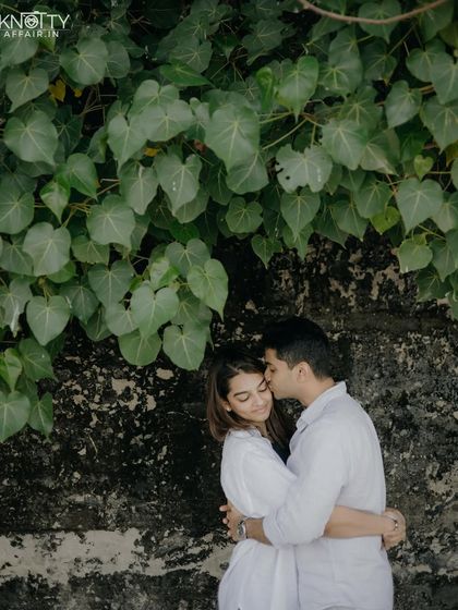 A quiet embrace against a wall of heart-shaped leaves. This natural backdrop adds a touch of organic beauty and symbolism to this intimate portrait.