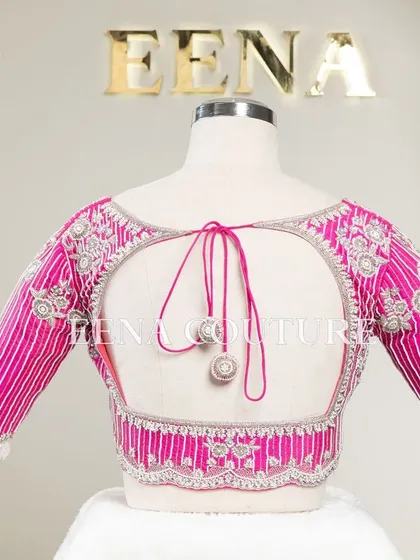 Pretty in pink, this raw silk blouse features intricate pearl and silver thread work in a striped pattern. I added floral motifs and delicate danglers on the sleeves for a touch of playful elegance.
