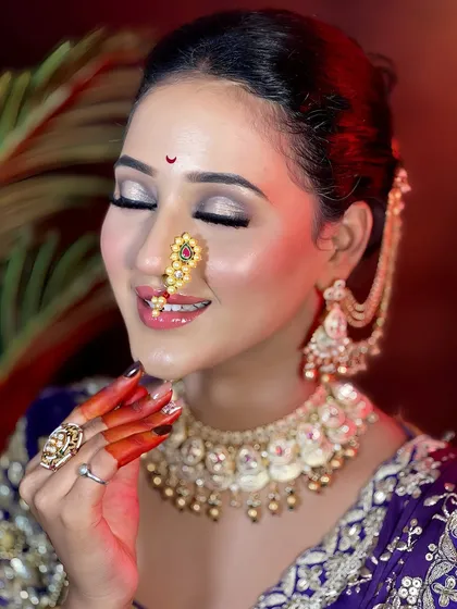 A serene bridal portrait showcasing soft, shimmering eye makeup and a traditional pearl and gold nath. This look is all about grace and elegance.