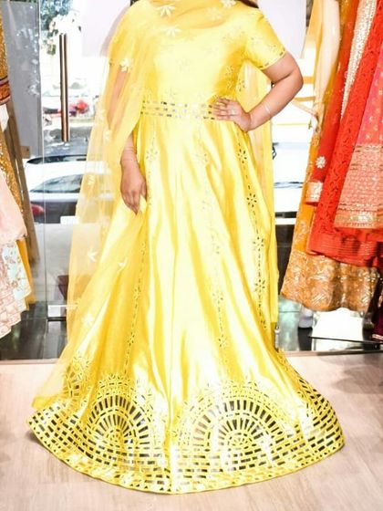 A full-length view of a vibrant yellow gown with unique laser-cut detailing at the hem. This modern design element makes it a standout piece for any party.