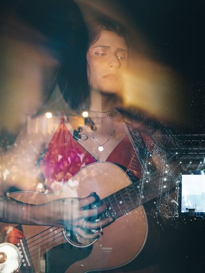 An artistic double exposure shot from a festival, capturing the dreamy, immersive feeling of being lost in the performance.
