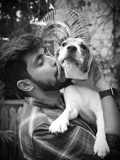 A sweet kiss for a sweet beagle. This black and white photo beautifully captures the love between a man and his dog.