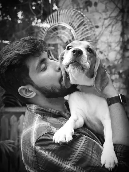 A sweet kiss for a sweet beagle. This black and white photo beautifully captures the love between a man and his dog.