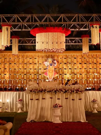 A wider view of the traditional stage setup. The intricate backdrop and large floral chandeliers create a stunning focal point for a cultural event or wedding ceremony.