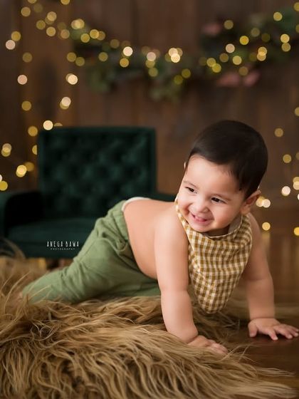 A cheeky sideways glance. This baby boy is captured mid-crawl, looking back at the camera with a playful grin.