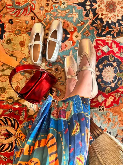 A vibrant, festive scene featuring my metallic silver ballet flats and a bright red bag. This image captures the celebratory spirit of the season and the versatility of a great metallic shoe.