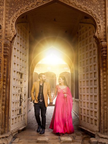 Stepping through a grand, sunlit doorway in a Jaisalmer fort. This shot symbolizes the beginning of a new chapter, with the light representing a bright future together. It's a powerful and optimistic image.