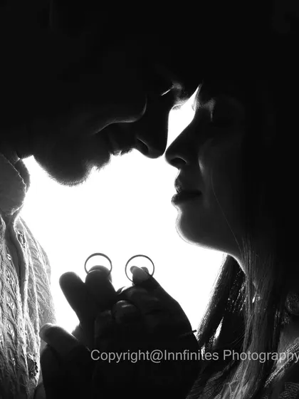 An artistic black and white silhouette of a couple, with their engagement rings held up to the light. This creative approach offers a timeless and dramatic portrait that stands out.