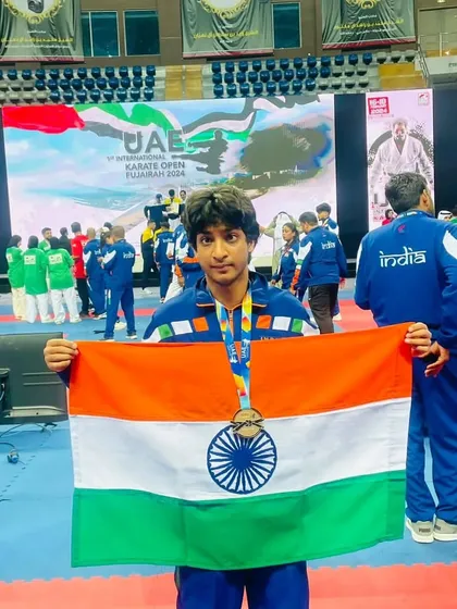 An athlete proudly displaying his medal and the Indian flag. Representing the country is the ultimate honor, and we train with that responsibility in mind.