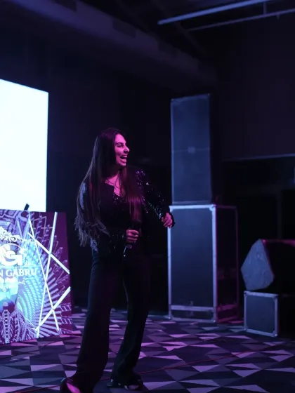 A female vocalist performing on stage, captured in a moment of passion. We work with top artists to ensure your event has world class entertainment.