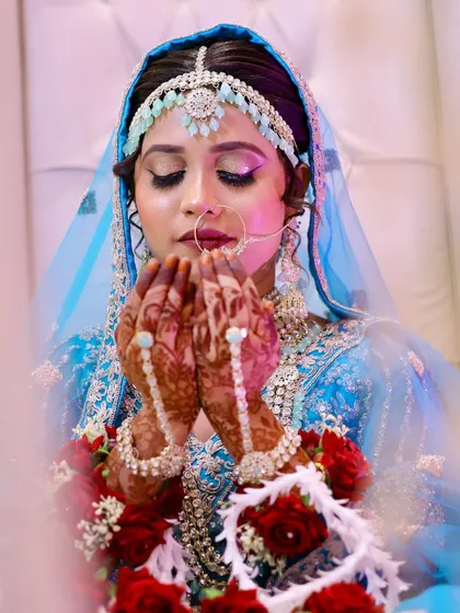 A serene moment for this beautiful Nikkah bride. Her look features soft, shimmery eyes and a delicate matha patti to complement her sky-blue outfit.