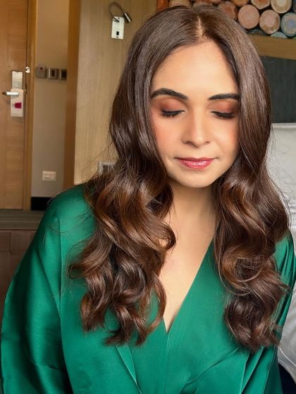 Soft, glamorous waves paired with subtle, earthy-toned makeup. This look is effortlessly chic, perfect for a client getting ready for a party in the comfort of her hotel room.