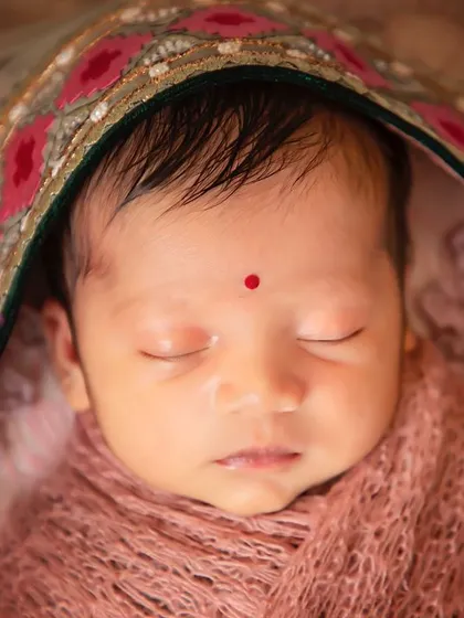 A close-up of a precious face, adorned with a traditional bindi. This shot combines cultural significance with the innocent beauty of a newborn.