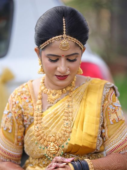 A detailed close-up of Rashmi's bridal makeup. Note the intricate embroidery on her blouse, which we complemented with bold eyes, a red lip, and traditional gold jewellery.
